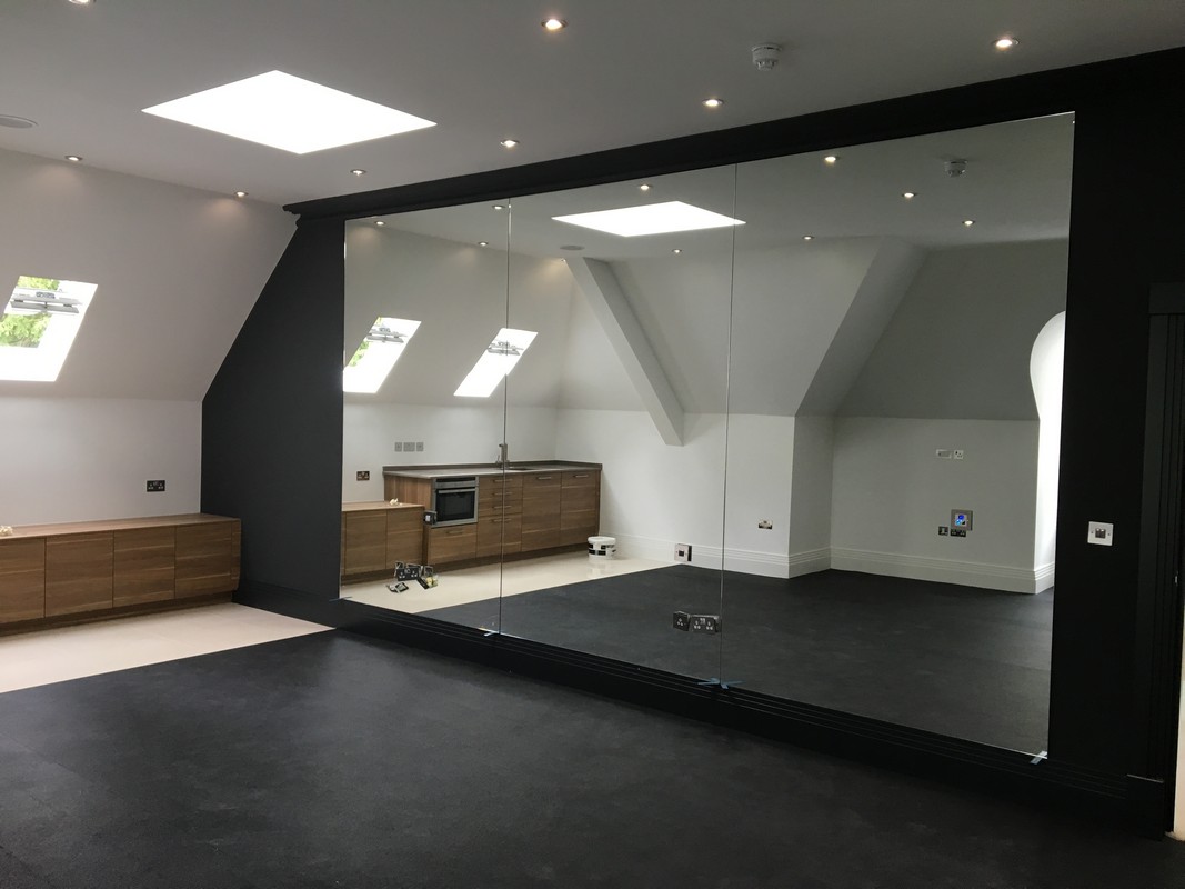 Frameless glass wall dividing loft conversion in Morden